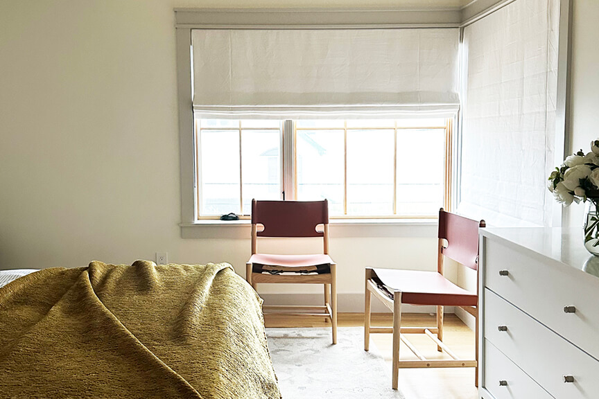 Primary bedroom with corner windows and soft natural light in a new construction beach house.