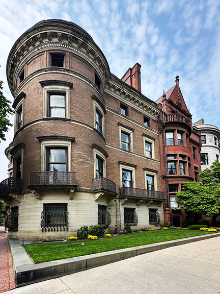 Chi Phi fraternity house at 307 Commonwealth Avenue with a rounded turret, sandstone base, and pale brick façade in Boston.