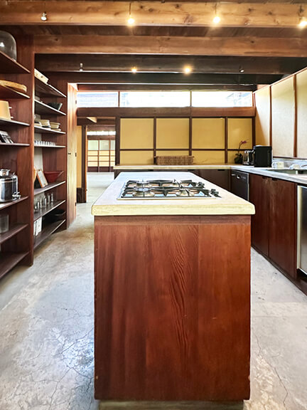Custom dark wood cabinets with yellow panels and concrete floors, part of postmodern architecture Los Angeles tour