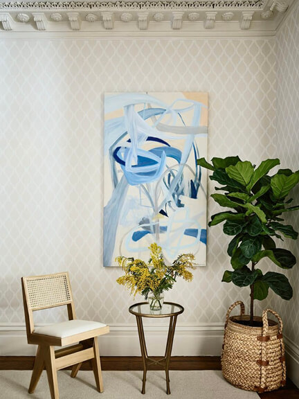 Art in interior design featuring commissioned abstract work in a brownstone renovation with classic architecture and layered wallpaper