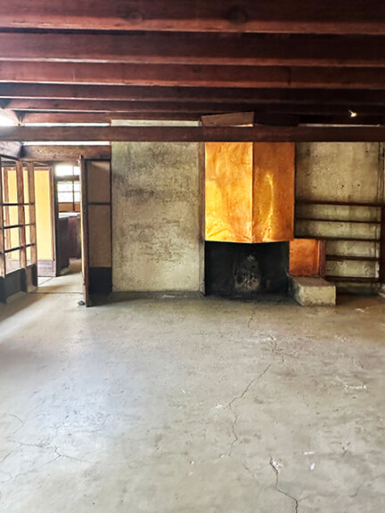 Copper fireplace mantel with concrete walls, shelves, and floors at Schindler House