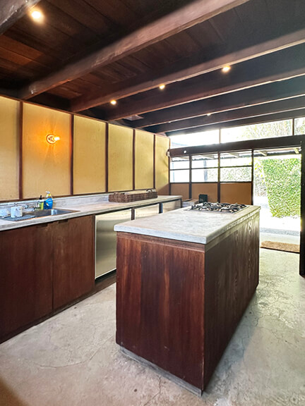 Dark wood cabinets and no uppers in Schindler House kitchen, part of postmodern architecture Los Angeles tour