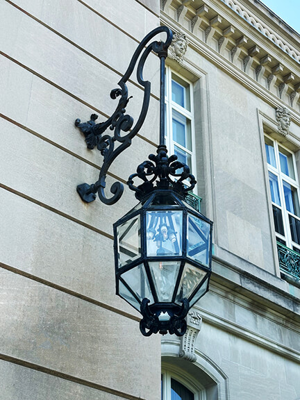 Historic home design with iron lantern light fixture mounted on the limestone wall at The Elms Newport mansion, an HBO Gilded Age filming location.