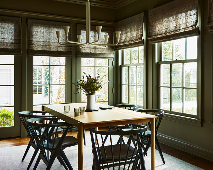 Boston interior designer updates dining room with garden doors, dark paint, natural light, modern lighting, and fresh furniture