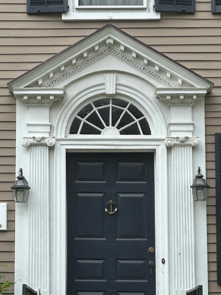 Federal-style front door with pilasters, fanlight, and triangular pediment photographed by New England historic home designer