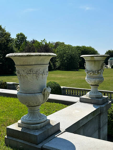 Decorative stone urns in the landscape design at The Elms, a Newport mansion, overlooking the back lawn and classic French garden.