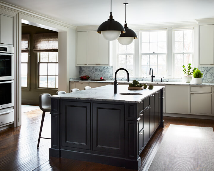 Boston kitchen designer updates a white kitchen with a black island, flat panel cabinets, edge pulls, and modern lighting touches