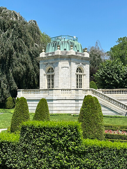 Marble pavilion with aged metal roof showing verdigris at the Gilded Age house, a French garden setting and filming location in Newport.