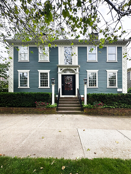 Deep blue New England home with fanlight and classical trim details.
