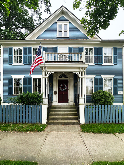 Traditional blue New England house in Bristol with fluted columns, fanlight, and coastal architectural elements