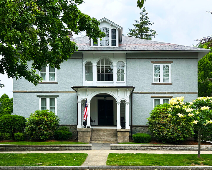 Blue stucco Italianate home with white trim and columns on State Street in Bristol. new england historic home designer