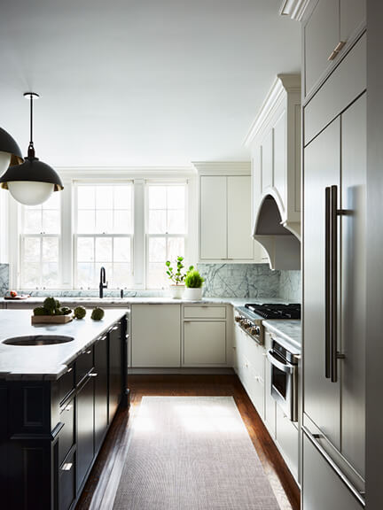 Easy kitchen makeover with white cabinets, black island, and Allied Maker light fixtures in a historic modern home