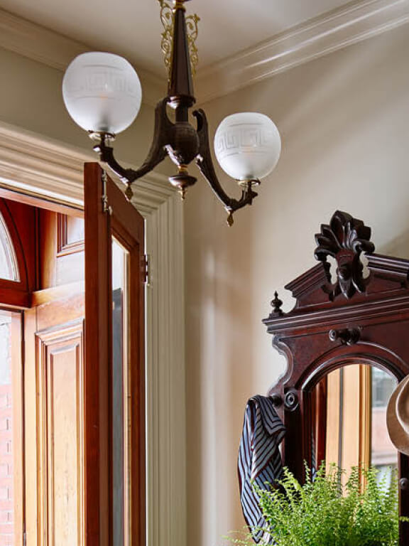 Boston brownstone interior designer with antique light fixture selected during design development in interior design