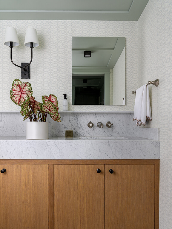 New construction powder room design with white oak cabinets and marble counter highlighted by custom details chosen during design development.