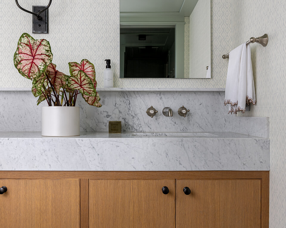 New construction powder room design with white oak cabinets and marble counter featuring refined selections during design development.