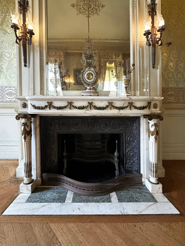 Historic fireplace at The Elms in Newport, showcasing marble and sculptural detail in a refined early 20th-century setting.