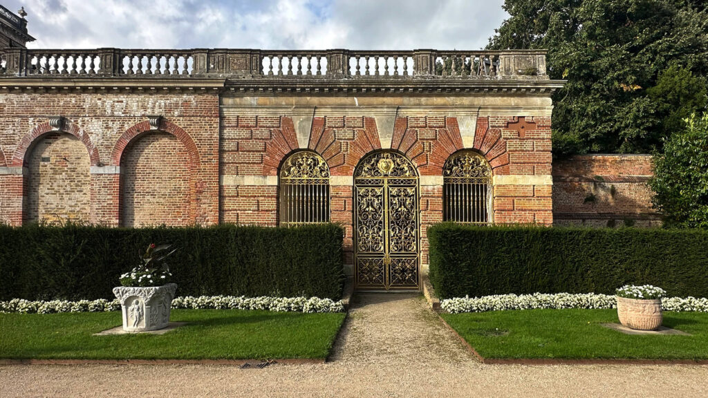 Historic English Estate Design reflected in the brick arcade at Cliveden House in Buckinghamshire, with arched openings and stone detailing.