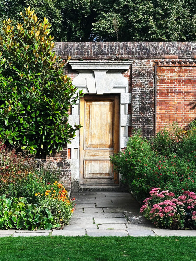Entrance doors of Cliveden House framed by carved stone columns, arched detailing, and the symmetry of classic English estate architecture.