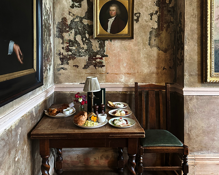 London restaurant design at Wilton Arms shows aged walls with layers of paint, vintage portraits, and fine art with intentionally imperfect finishes.