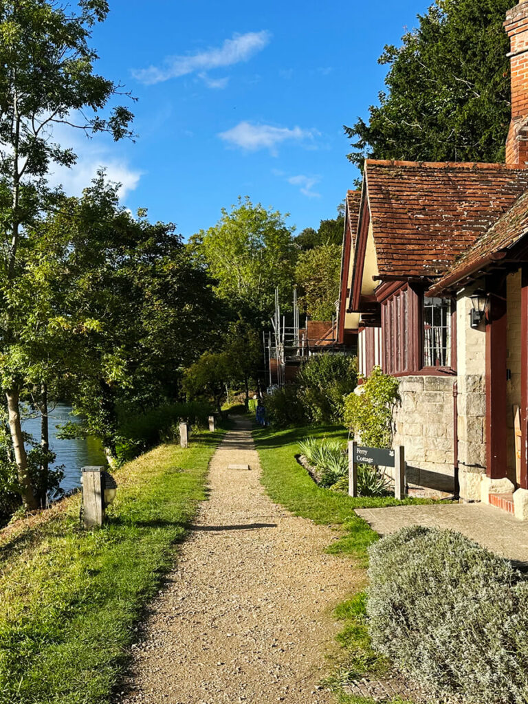 English cottage on the Thames River at a Buckinghamshire estate, featuring brick walls, timber beams, and leaded glass windows.