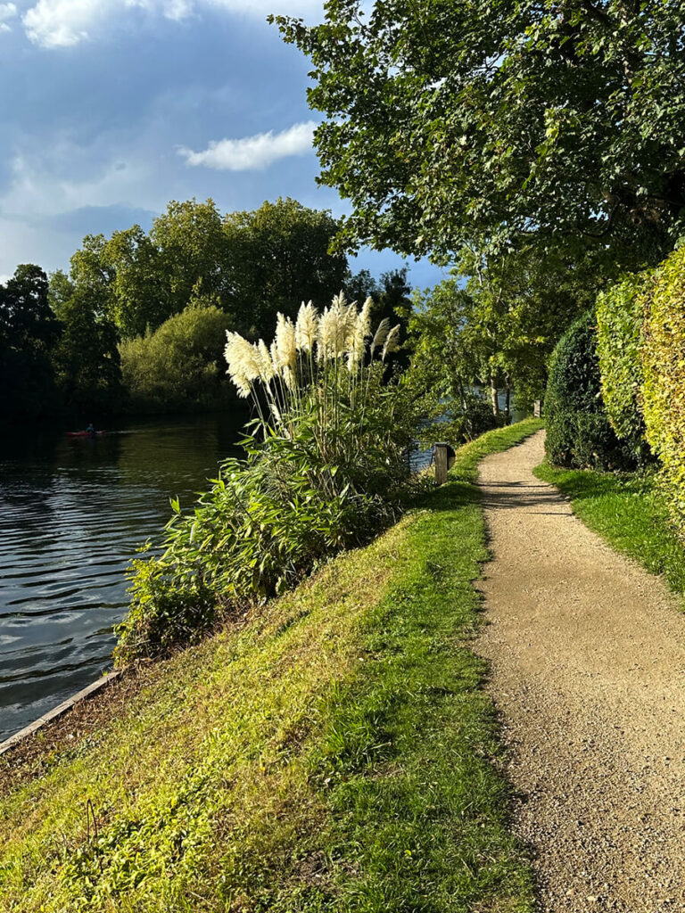 English countryside landscape along the Thames River, featuring rolling hills, wooded banks, and distant views from Cliveden House.