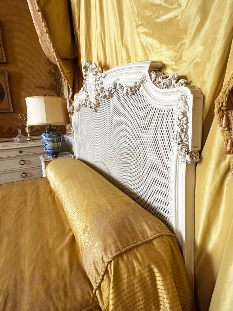 Gold silk bedding in a historic bedroom at The Elms in Rhode Island, a refined detail of Gilded Age Interior Design.