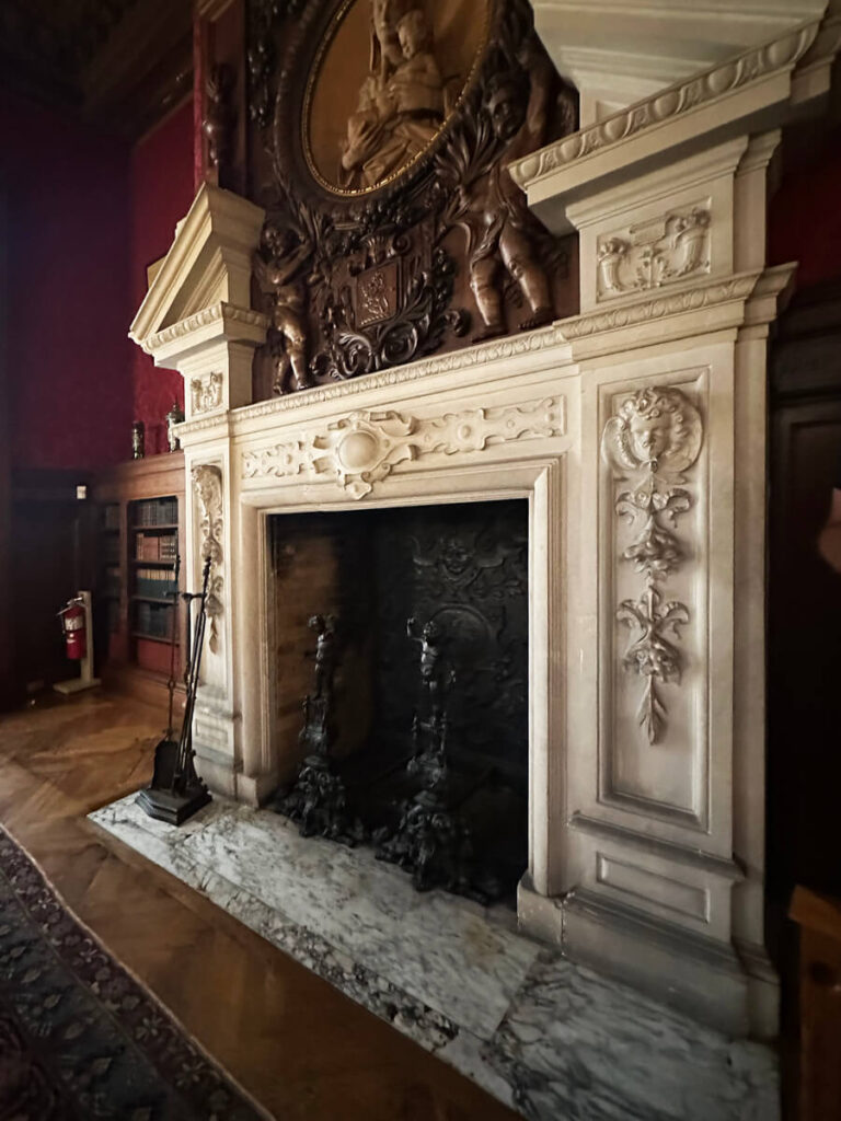 Historic fireplace at The Elms in Newport with marble surround and carved details, a refined element of Gilded Age Interior Design.