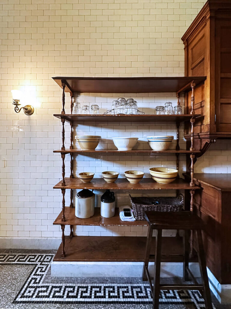 Terrazzo flooring and natural wood cabinets in the historic kitchen at The Elms in Newport, blending beauty and practicality.