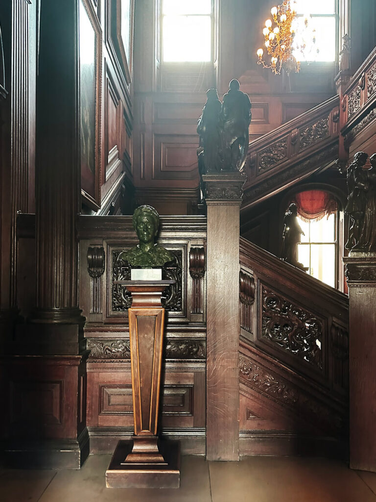 Historic staircase at Cliveden House with carved wood details, showcasing English manor interior design.