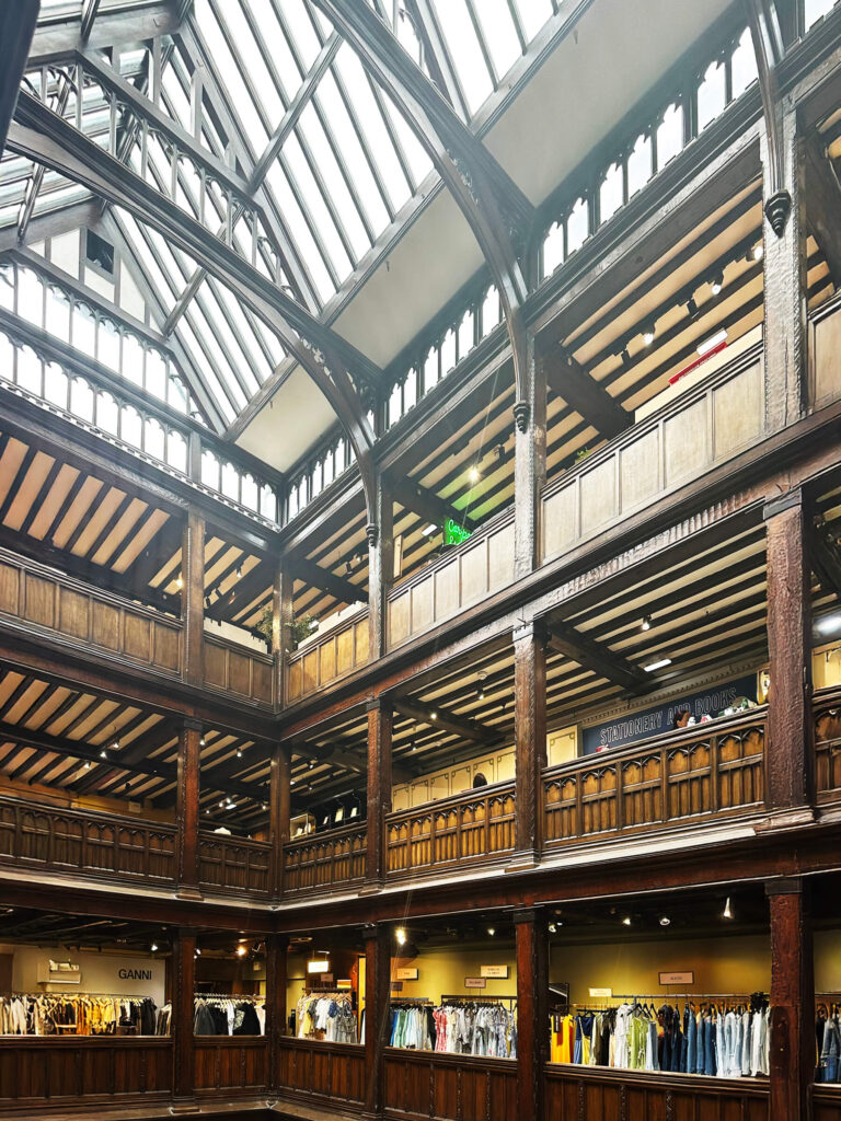 Boston interior decorator visits Liberty London interior, showing carved wood details and open multi-level galleries.