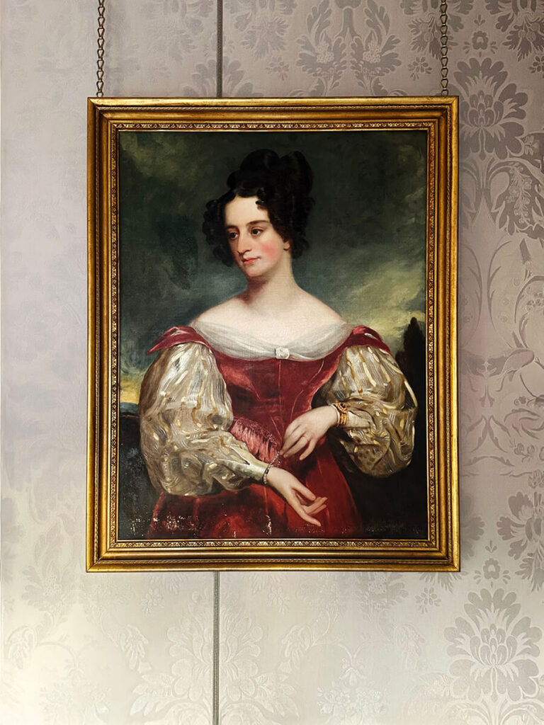 Light purple damask wallpaper and vintage art in a historic English home, admired by a Boston interior designer.