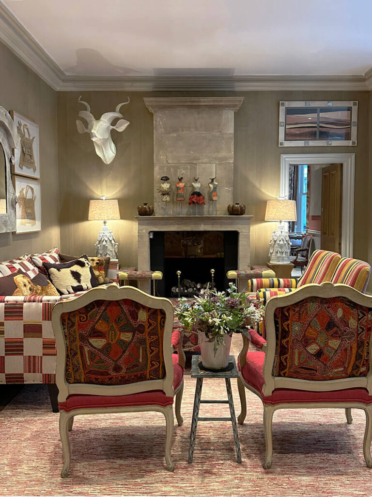 Colorful interior design at Kit Kemp’s Knightsbridge Hotel featuring red vintage textiles and layered hospitality details.