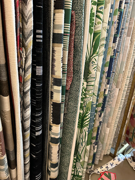Christopher Farr Cloth luxury fabric in green and black displayed in the showroom.