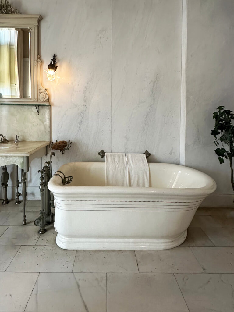 Marble bathroom with a large tub at The Elms in Newport, a luxurious example of Gilded Age Interior Design.