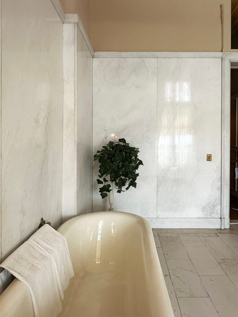 Marble walls and tub in a historic New England bathroom at The Elms, showcasing classic materials and craftsmanship.