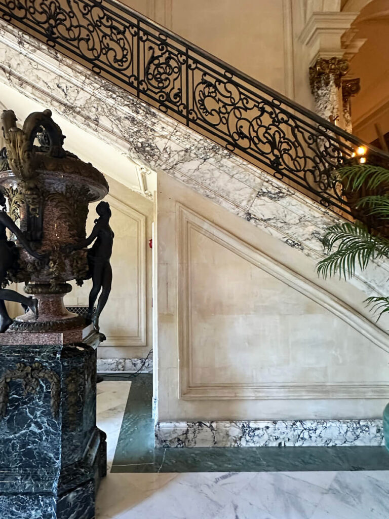 Marble staircase with wrought iron railing at The Elms in Newport, a dramatic example of Gilded Age Interior Design.