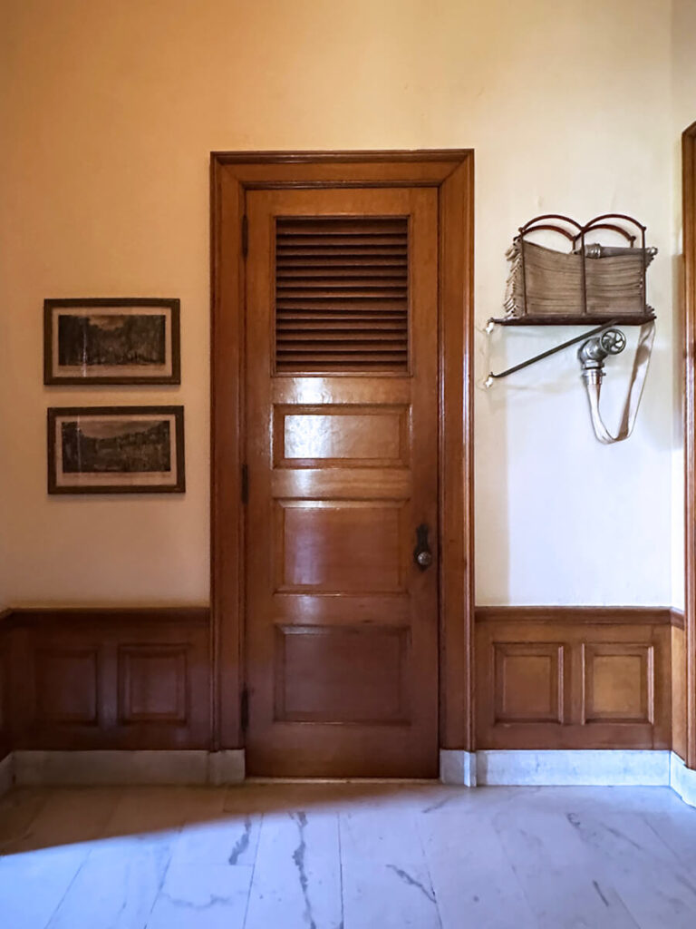 Natural wood door and wainscot at a historic New England home, showcasing the elegance of Gilded Age Interior Design.