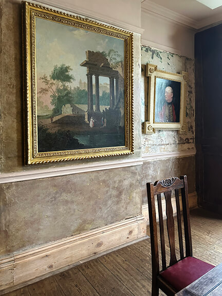 London restaurant design at Wilton Arms highlights layered paint on aged walls, vintage portrait art, and period furniture in a historic pub setting.