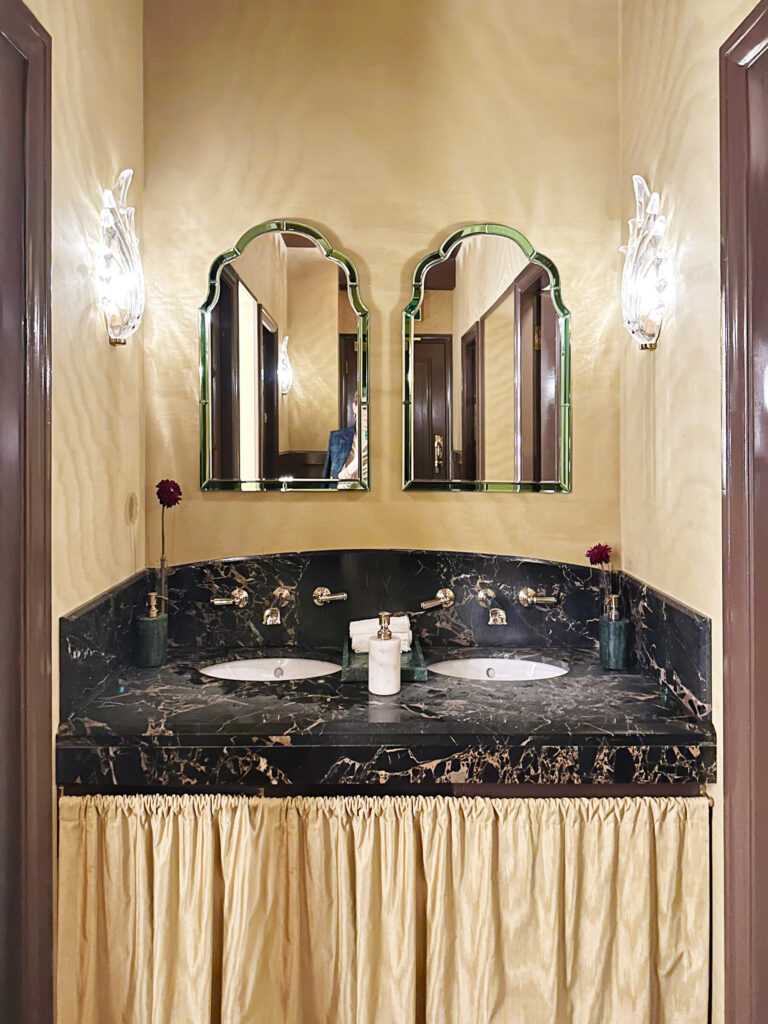 Skirted bath vanity at British restaurant design cool interior at Tramp with moiré wallpaper and a marble counter, reflecting London restaurant design.