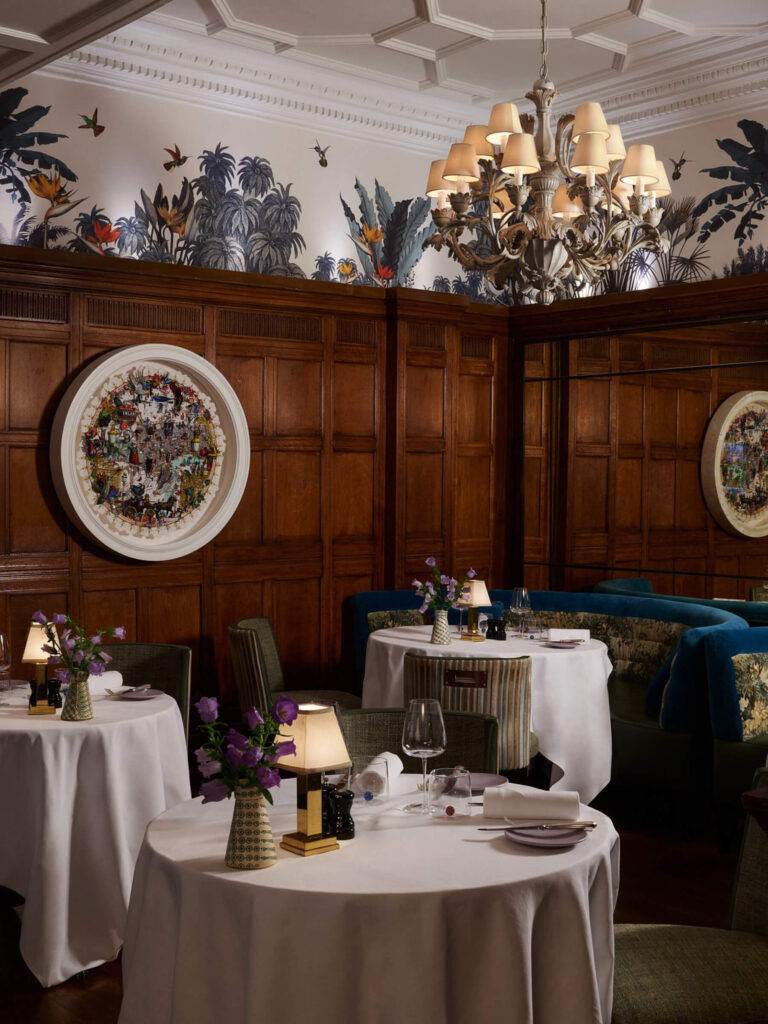 Restaurant design London Brown’s Hotel wood paneling, red velvet chairs, classic wallpaper, and an ornate ceiling reflecting London restaurant design.