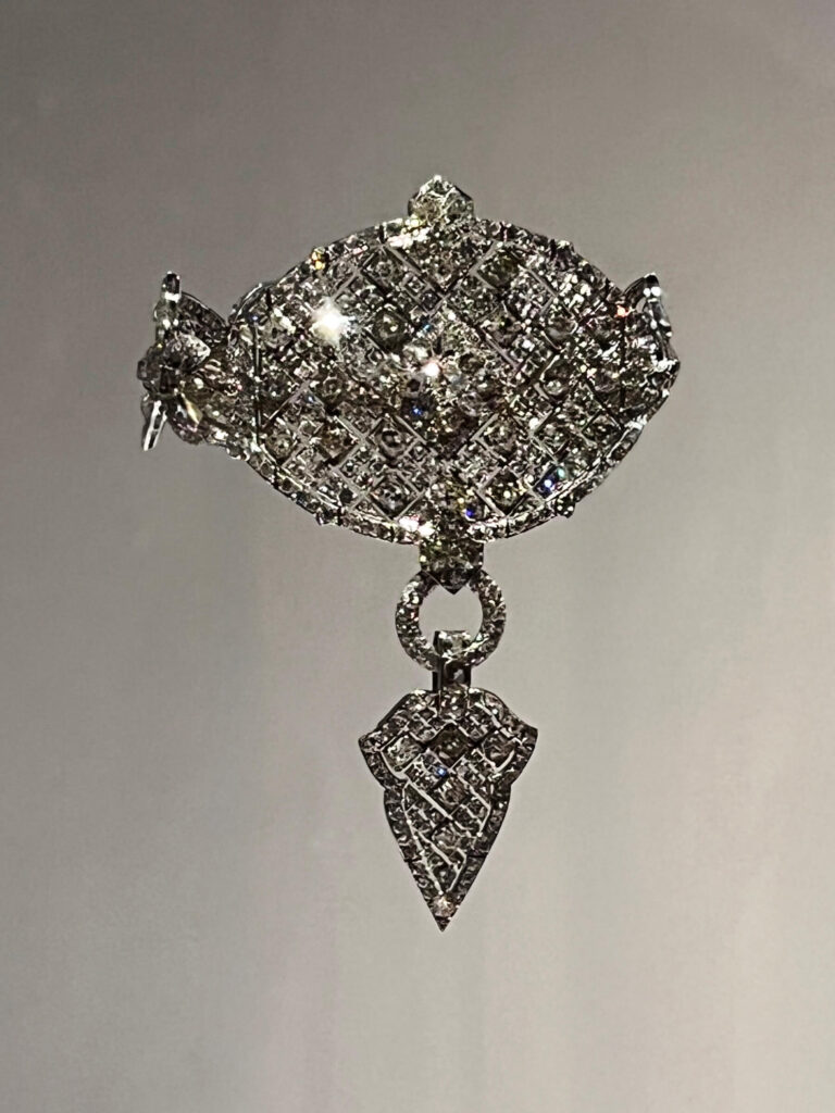 A Cartier bazuband arm bracelet inspired by Indian design with ornate metalwork and gemstones.