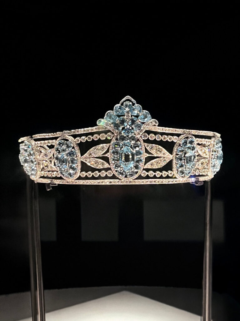 A display of a Cartier gemstone tiara with bright, faceted stones and platinum detailing.