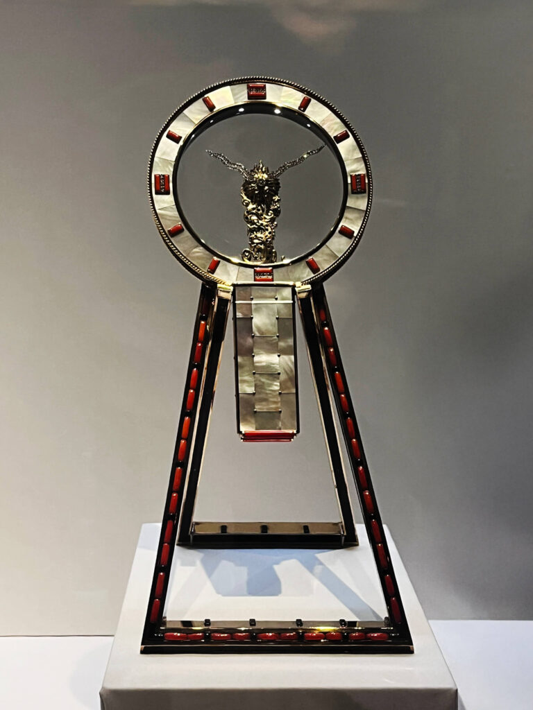 A 1945 Cartier Japanese mirror clock with lacquer, coral, enamel, and metal inlay.