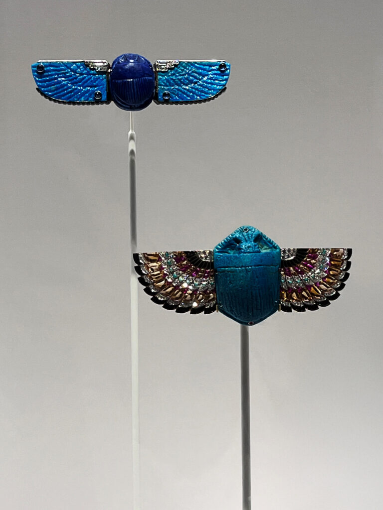 Cartier scarab brooches made with faience, rubies, emeralds, and diamonds displayed in the Cartier Jewelry Exhibit.