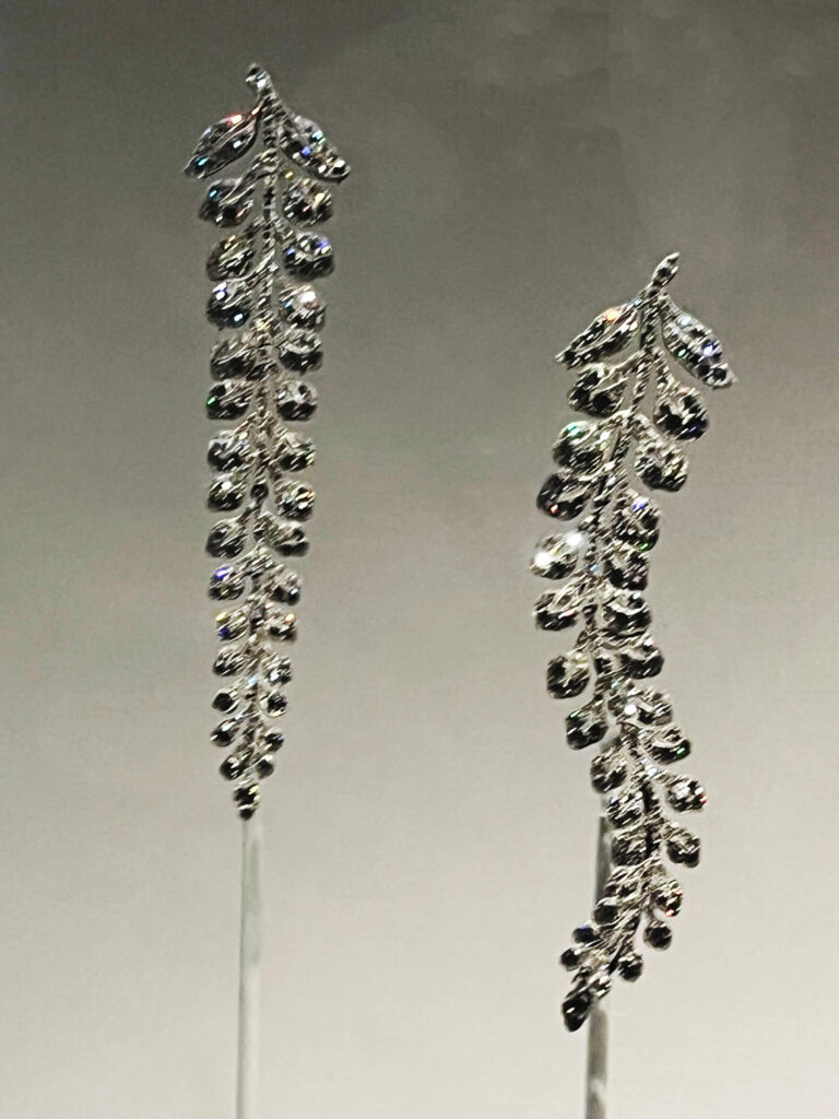 Delicate Cartier wisteria brooches with cascading gemstones displayed in the Cartier Jewelry Exhibit.