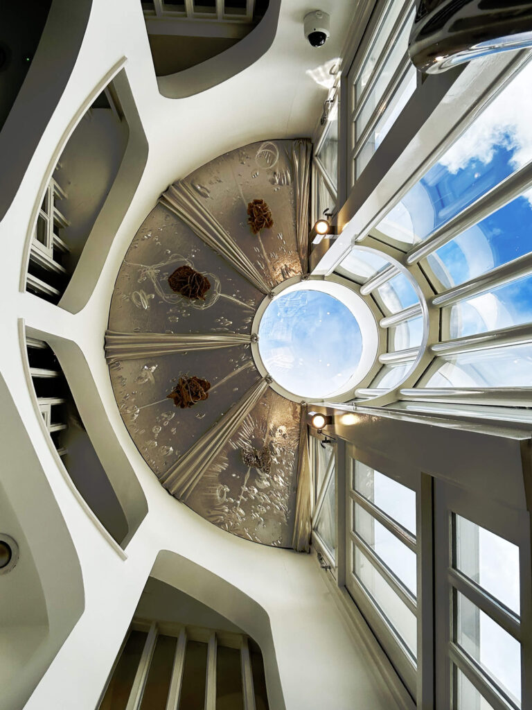 The Cosmic House London atrium with circular ceiling and metallic skylight detail