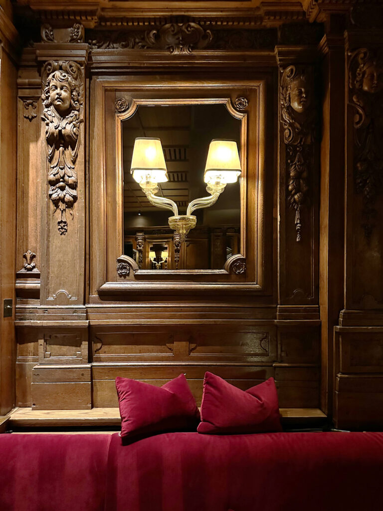 London restaurant and club design Tramp with red custom banquettes set against historic woodwork, a striking detail in London restaurant design.