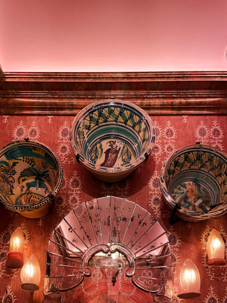 Pink inspired interior design at London private restaurant with wallpaper and vintage ceramics, expressing layered London restaurant design.