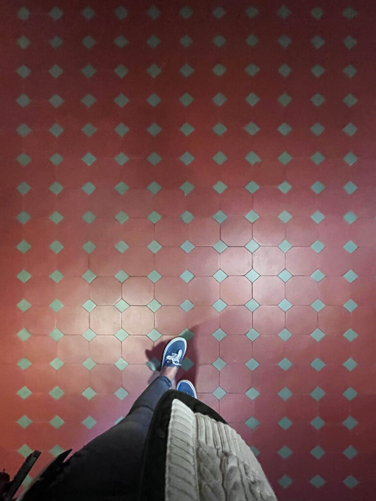 Red and green encaustic tiles form a bold historic pattern inside a London museum, offering inspiration for an old home renovation project.