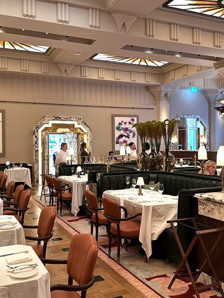 Claridge’s London interior design art deco interiors at the restaurant with leather chairs and custom ceiling millwork, reflecting London restaurant design.